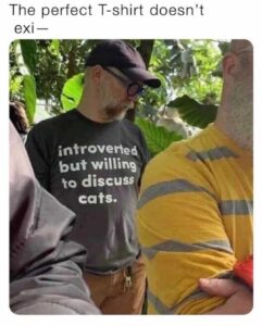 Photo of a man wearing t-shirt saying "introverted but willing to discuss cats"